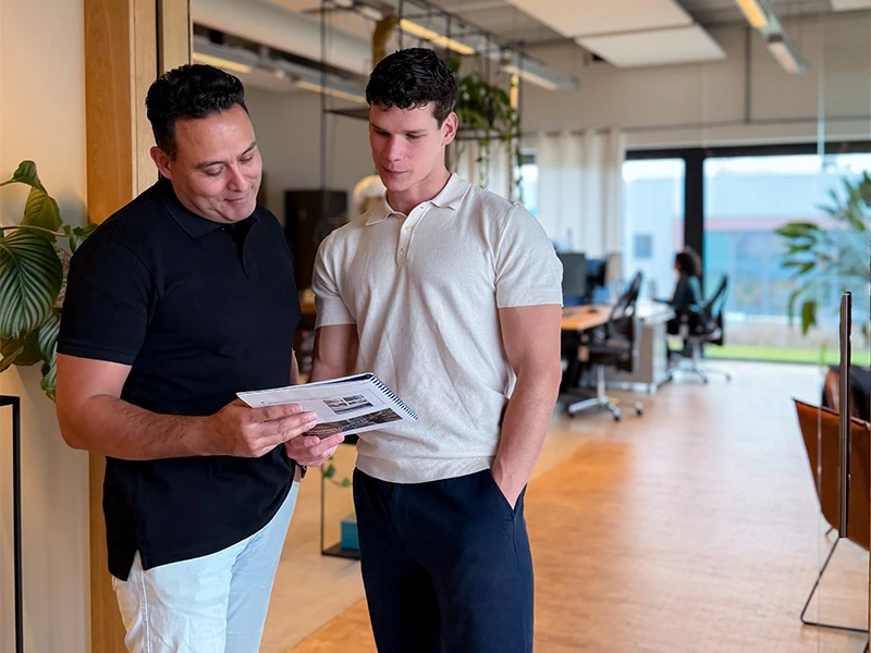 David en Max staan samen in een boekje te kijken over data-consultancy.