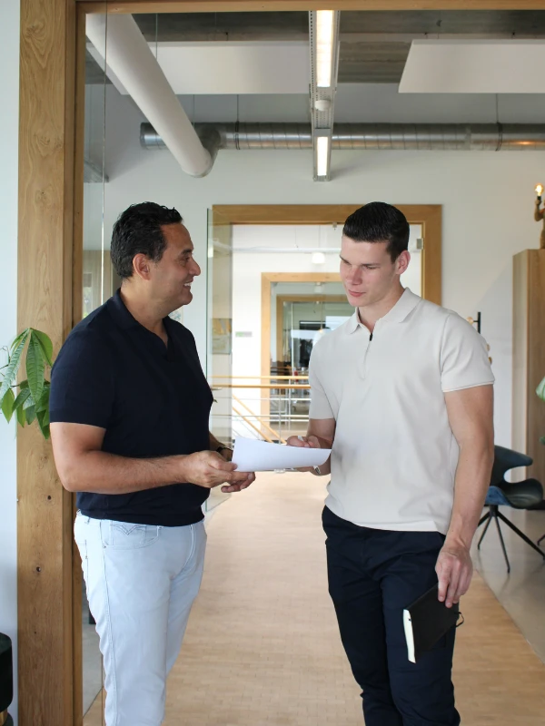 David en Max bespreken online marketing-consultancy in het kantoor.