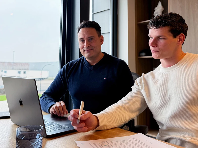 David en Max kijken samen op de laptop naar online marketing-diensten.