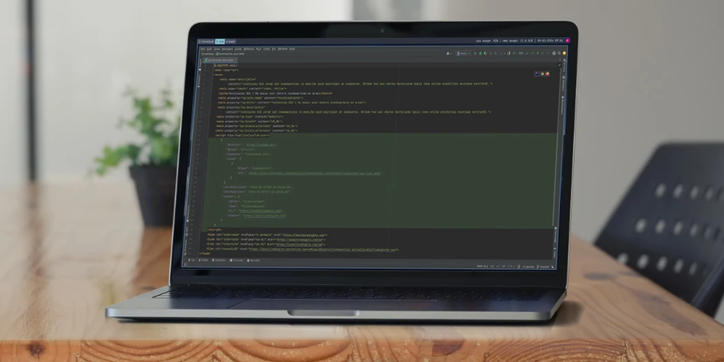 Laptop met code-editor op bureau, illustratie van technische SEO.