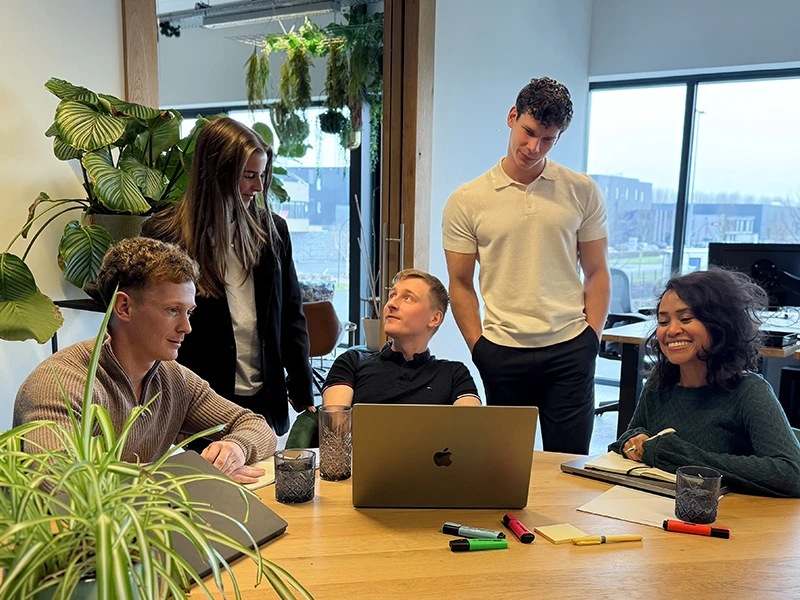 Teamoverleg over online marketing met laptops aan vergadertafel