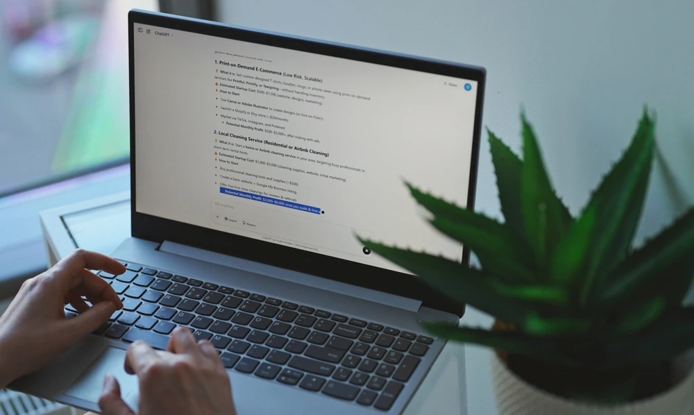 Persoon werkt op laptop met GEO gerelateerde content op het scherm in een rustige werkomgeving.