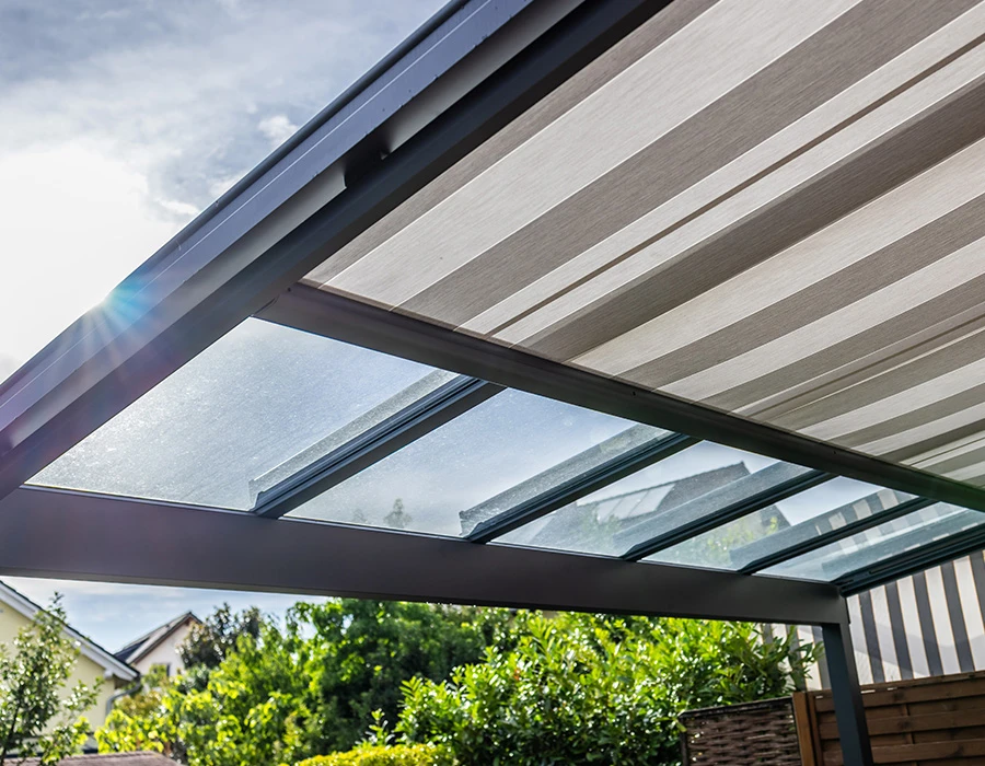 Zonwering met glazen overkapping en elektrisch doek bij een woning.