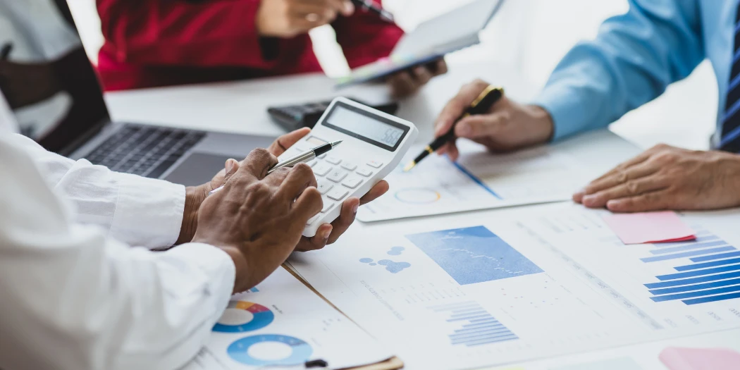 Team analyseert e-commercecijfers met grafieken en calculator voor omzet en prestaties.